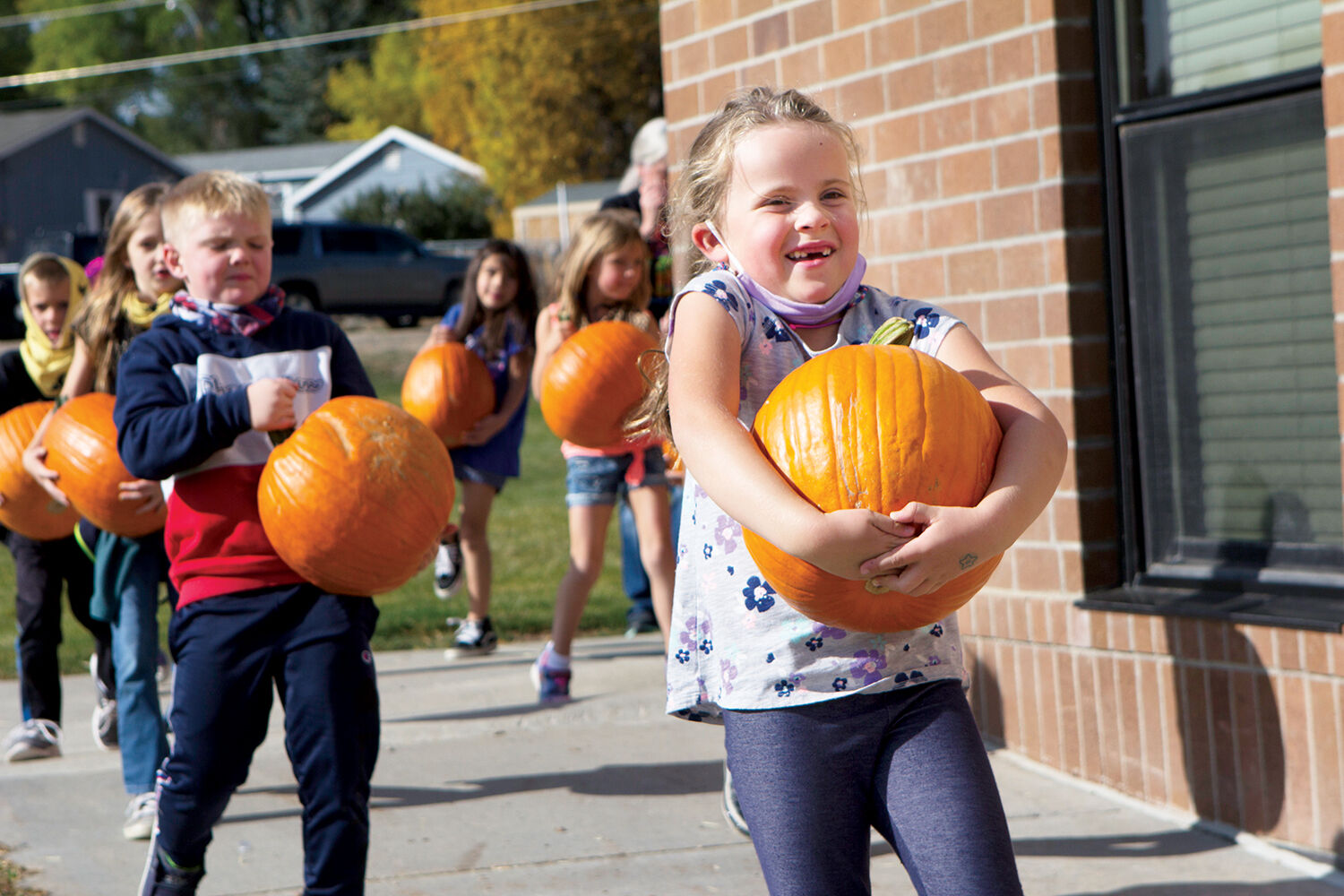 Kennedy McCoy is all smiles as she carries her pumpkin